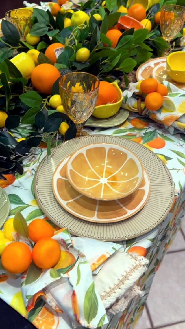 Mesa posta vibrante com louças e arranjo de frutas